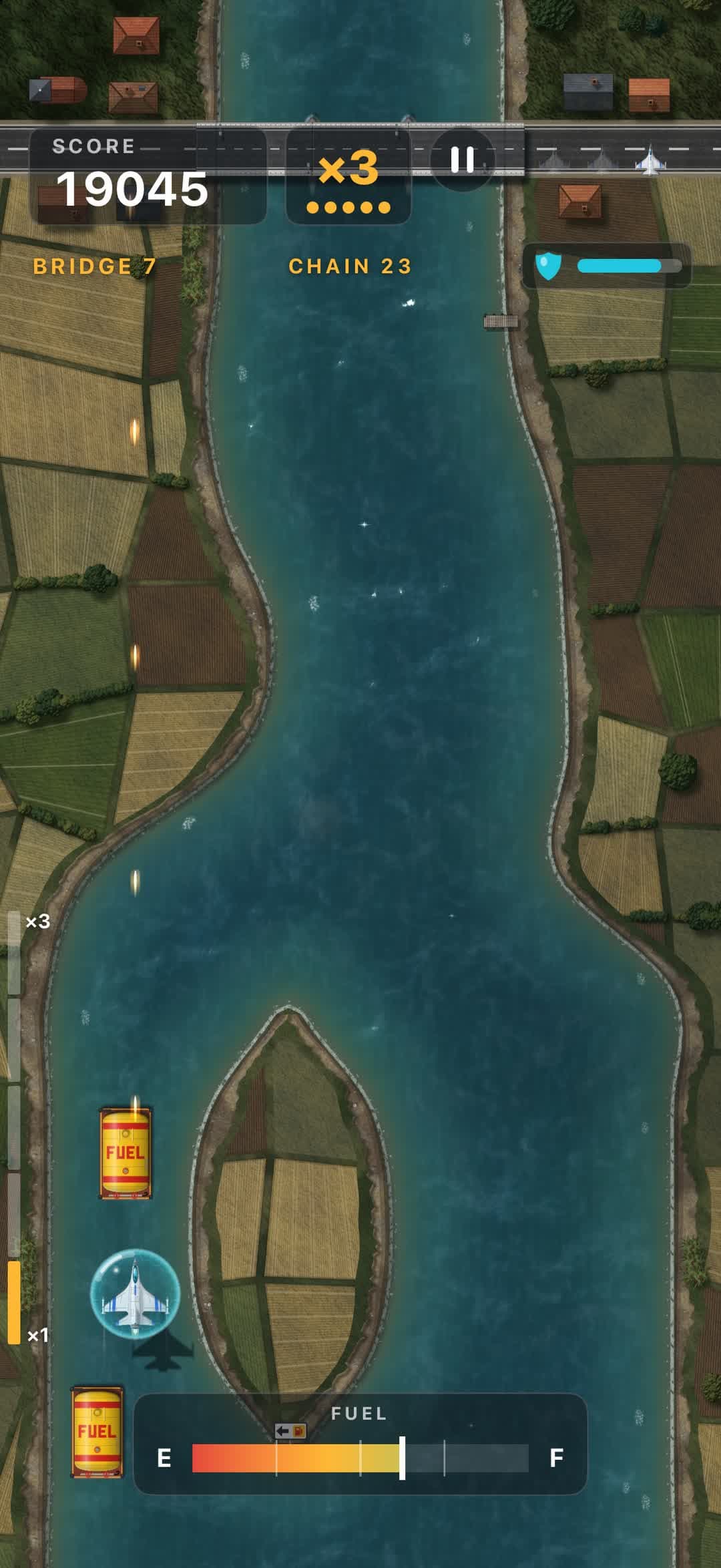 A shield surrounds the jet between farmland fields, with a bridge and its village ahead.
